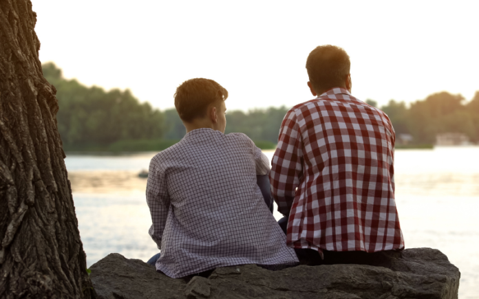 Things to Consider When Your Child Turns 18 father and son sitting together outside