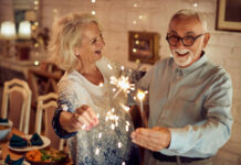 2025 Was a Very Good Year for Texas Seniors Happy mature couple using sparklers and having fun together on Christmas day at home.